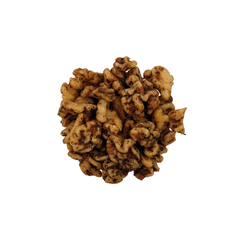 A top-down view of salted walnuts in a clear glass bowl on a plain white background.