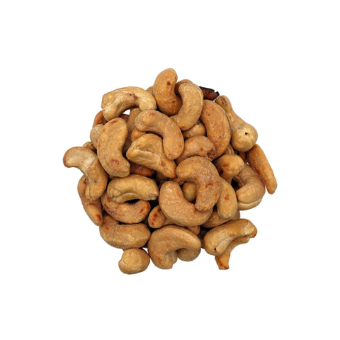 Salted cashews in a clear glass bowl, photographed from a top-down view on a plain white background.