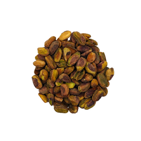 A clear glass bowl filled with roasted salted pistachios, photographed from above on a plain white background.