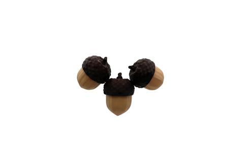 Three acorn-shaped fidget toys hovering against a plain light gray studio background.