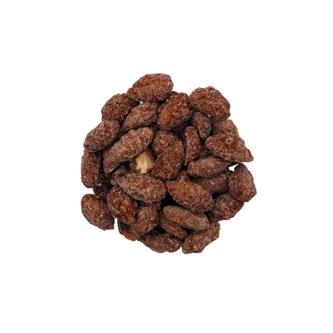 A clear glass bowl filled with brown cinnamon glazed almonds, photographed from a top-down view on a clean white background.