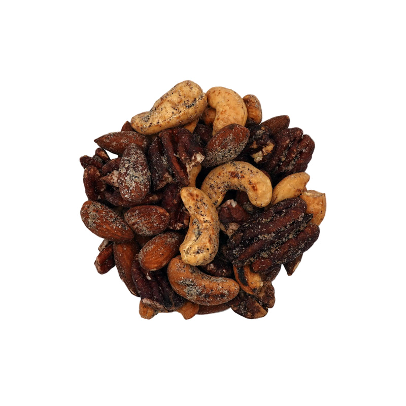 A clear glass bowl filled with Everything Bagel Seasoned Nuts, photographed from above on a plain white background.